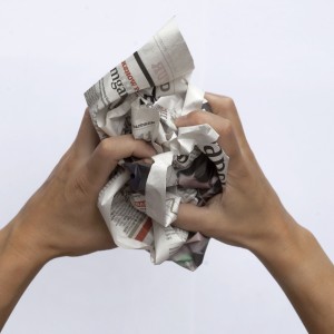 Hænder krøller en avis